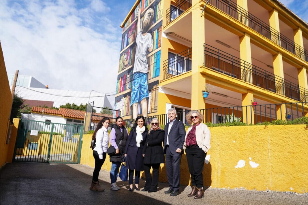 El artista 'Bestror' plasma en el CEIP Santo Tomás de Aquino de Estepona el tercer mural del colegio, dedicado a su biblioteca